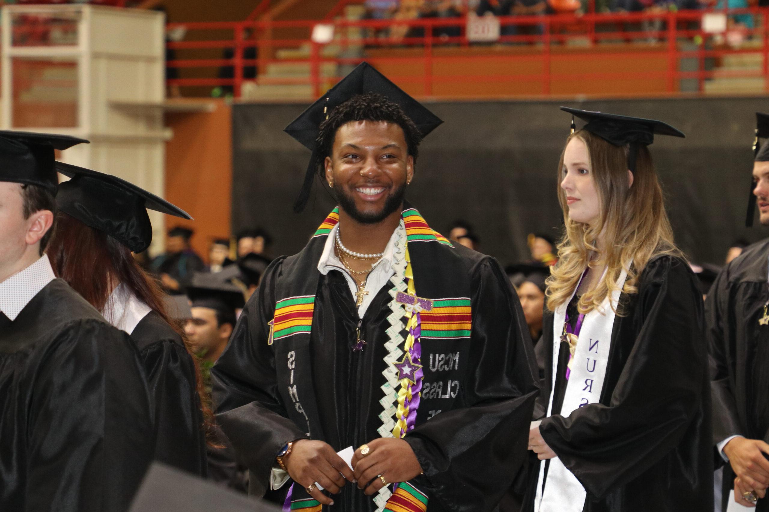 Man in graduation attire smiling